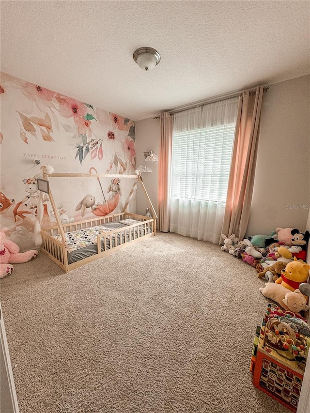 rec room featuring a textured ceiling and carpet floors