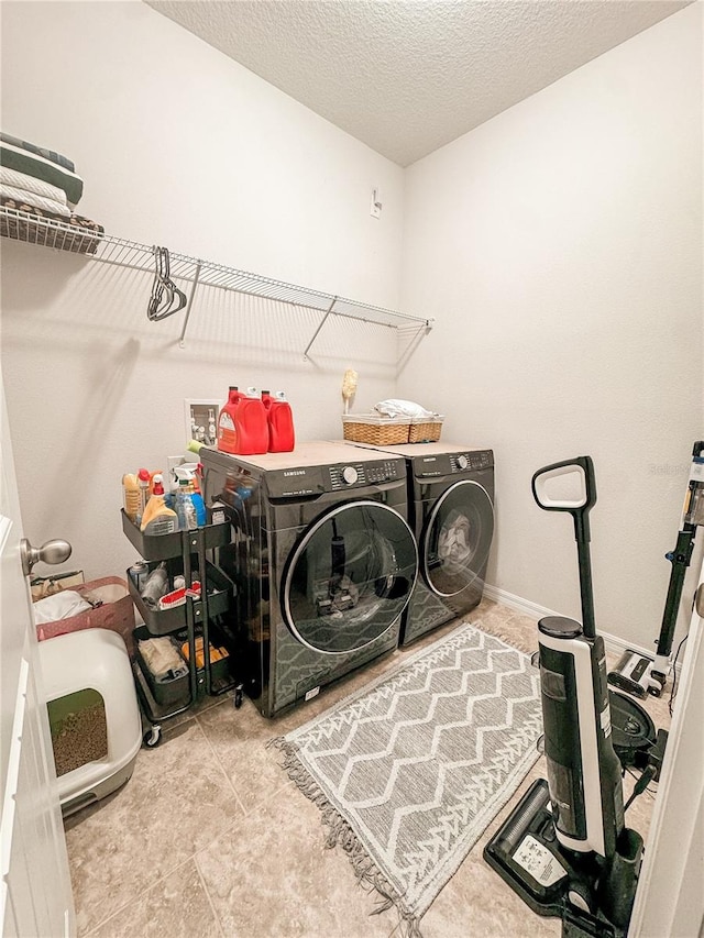 laundry room featuring washer and dryer and a textured ceiling