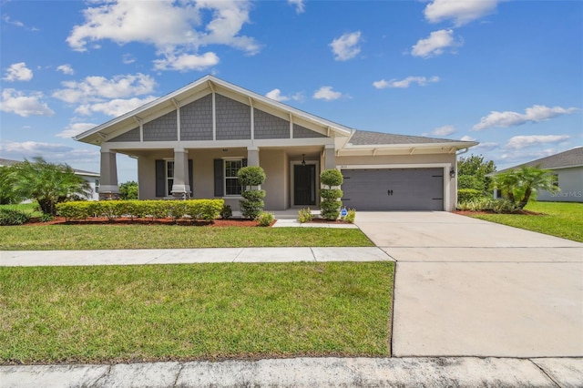 craftsman inspired home with a garage, covered porch, and a front lawn