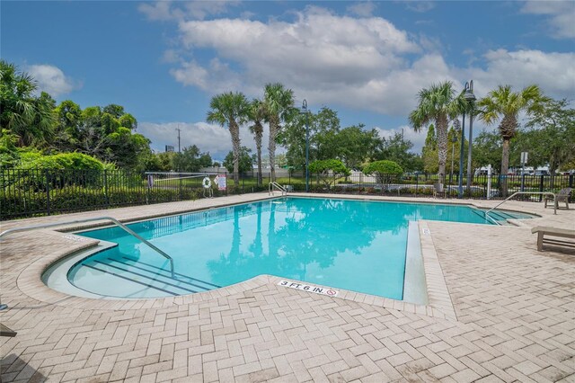 4177 N Orange Blossom Trl Unit 210, Orlando, FL 32804 - community pool featuring fence, a patio, and view of scattered trees