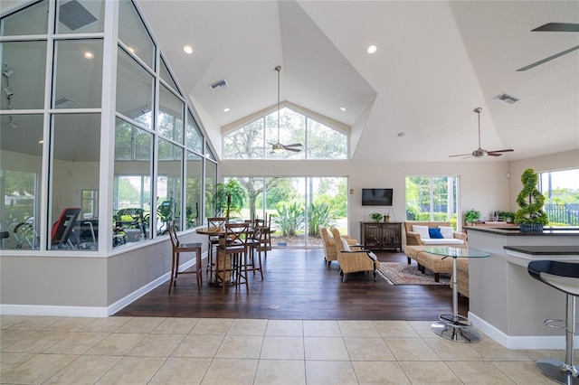 4177 N Orange Blossom Trl Unit 210, Orlando, FL 32804 - tiled dining room with ceiling fan, baseboards, and high vaulted ceiling
