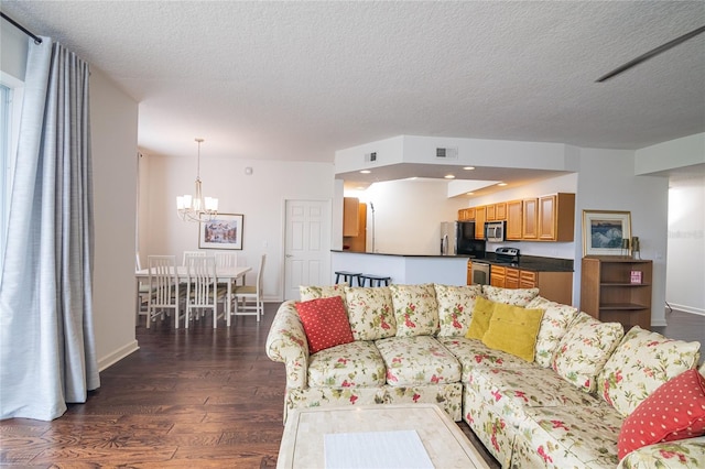 4177 N Orange Blossom Trl Unit 210, Orlando, FL 32804 - living room featuring a chandelier, dark wood-type flooring, a textured ceiling, and baseboards