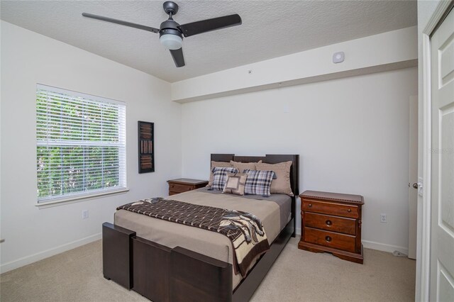 4177 N Orange Blossom Trl Unit 210, Orlando, FL 32804 - bedroom with light colored carpet, baseboards, ceiling fan, and a textured ceiling