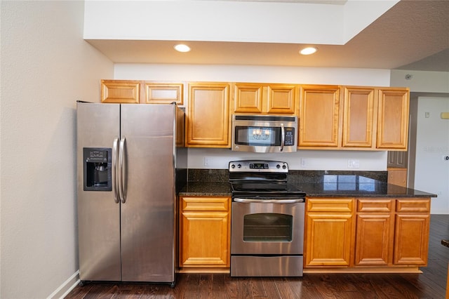 4177 N Orange Blossom Trl Unit 210, Orlando, FL 32804 - kitchen featuring appliances with stainless steel finishes, recessed lighting, dark wood finished floors, baseboards, and dark stone counters