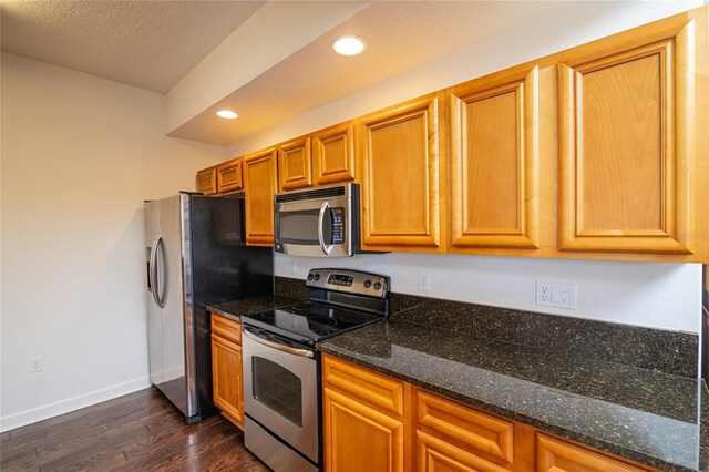 4177 N Orange Blossom Trl Unit 210, Orlando, FL 32804 - kitchen with appliances with stainless steel finishes, dark wood-type flooring, baseboards, recessed lighting, and brown cabinets