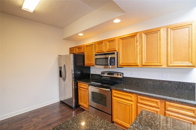 4177 N Orange Blossom Trl Unit 210, Orlando, FL 32804 - kitchen featuring stainless steel appliances, recessed lighting, dark wood-style floors, baseboards, and dark stone counters