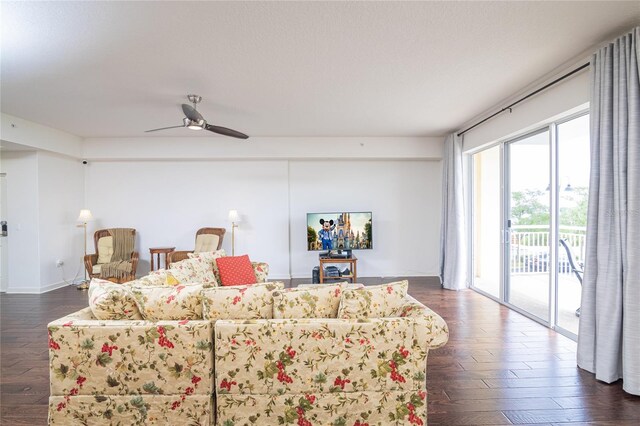 living room featuring ceiling fan and dark hardwood / wood-style floors