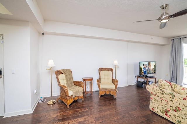 sitting room with a textured ceiling, ceiling fan, and dark wood-type flooring