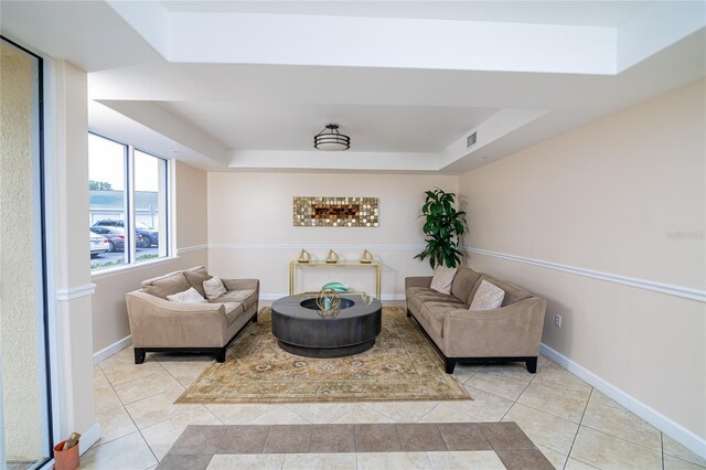 4177 N Orange Blossom Trl Unit 210, Orlando, FL 32804 - tiled living room featuring a tray ceiling and baseboards