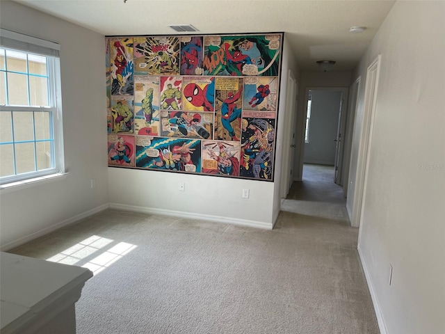 carpeted spare room featuring a wealth of natural light