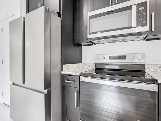 kitchen featuring appliances with stainless steel finishes and light stone counters