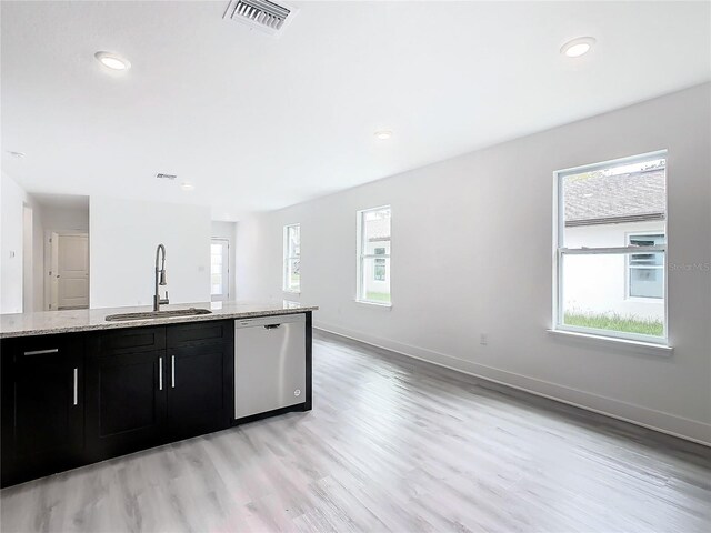 kitchen featuring stainless steel dishwasher, a healthy amount of sunlight, sink, and light hardwood / wood-style floors