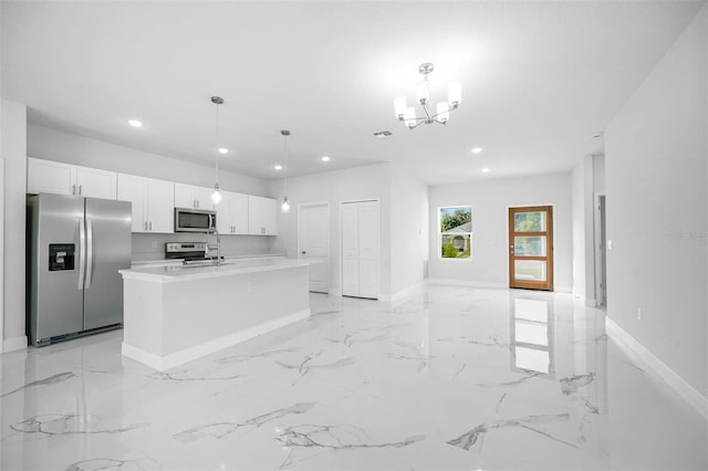 kitchen with a kitchen island with sink, appliances with stainless steel finishes, white cabinetry, and pendant lighting