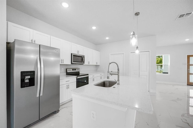 kitchen featuring appliances with stainless steel finishes, decorative light fixtures, white cabinetry, sink, and a kitchen island with sink