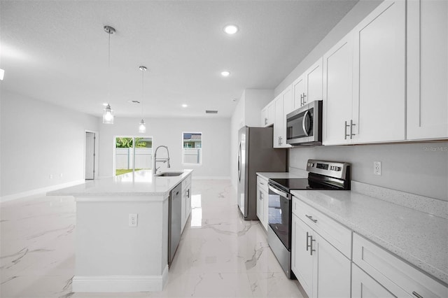 kitchen featuring a center island with sink, pendant lighting, sink, stainless steel appliances, and white cabinets