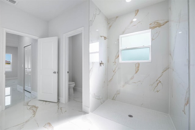 bathroom featuring a shower and toilet