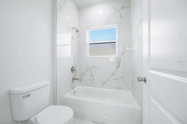 bathroom featuring tiled shower / bath combo and toilet