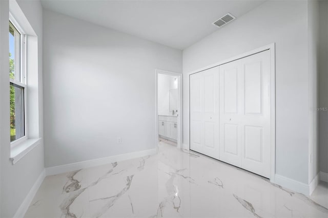 bedroom with ensuite bathroom and a closet