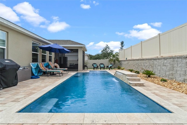 view of swimming pool with area for grilling, a patio area, and pool water feature