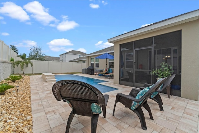 view of patio / terrace featuring a sunroom and a fenced in pool