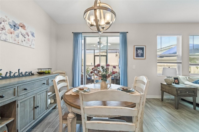 dining room with light wood-type flooring and an inviting chandelier