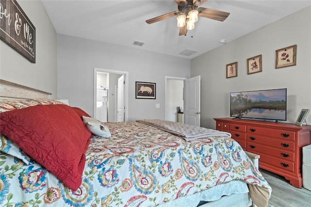 bedroom with hardwood / wood-style floors, ensuite bath, and ceiling fan