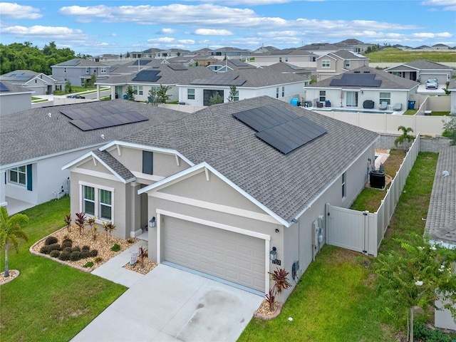 single story home featuring a front yard, cooling unit, a garage, and solar panels