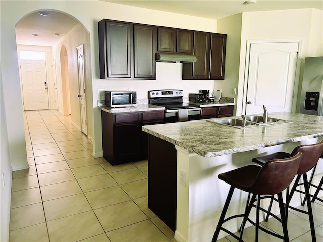 kitchen featuring a kitchen island with sink, appliances with stainless steel finishes, sink, and light tile patterned flooring