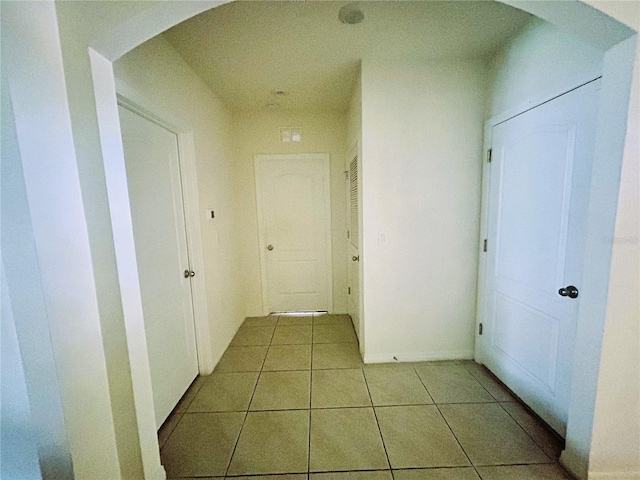 hall with light tile patterned floors