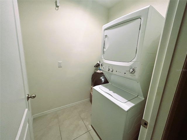 laundry area with light tile patterned flooring and stacked washer and dryer