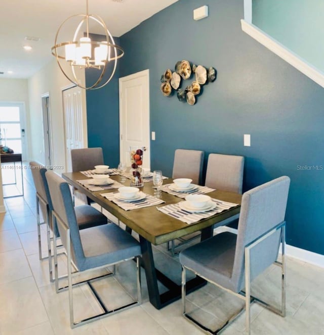 tiled dining room with an inviting chandelier