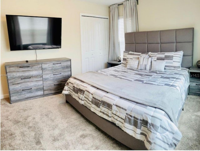 bedroom with light colored carpet and a closet