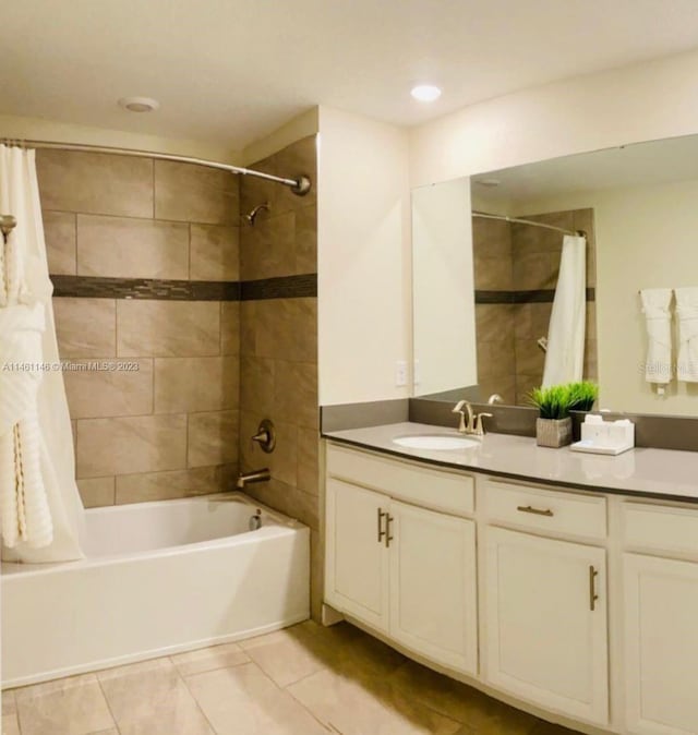 bathroom with tile patterned floors, shower / bath combo with shower curtain, and vanity