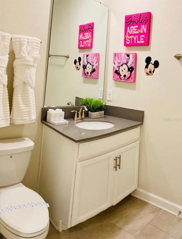 bathroom with vanity, toilet, and tile patterned floors