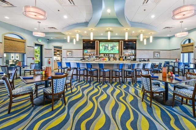 carpeted dining area featuring indoor bar