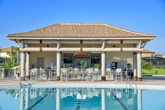 back of property with a community pool and a patio