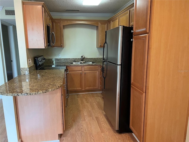 4814 Conway Rd Unit 141, Orlando, FL 32812 - kitchen featuring visible vents, a sink, appliances with stainless steel finishes, crown molding, and light wood-style flooring