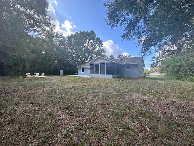 back of house with a lawn, a patio, and a sunroom