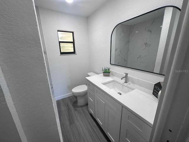 bathroom with vanity, hardwood / wood-style flooring, and toilet