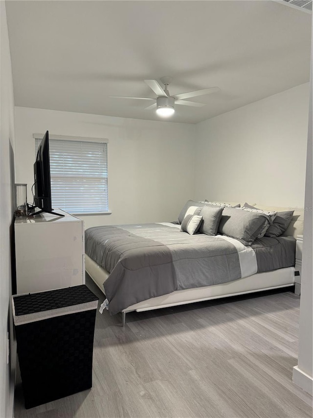 bedroom with light hardwood / wood-style floors and ceiling fan