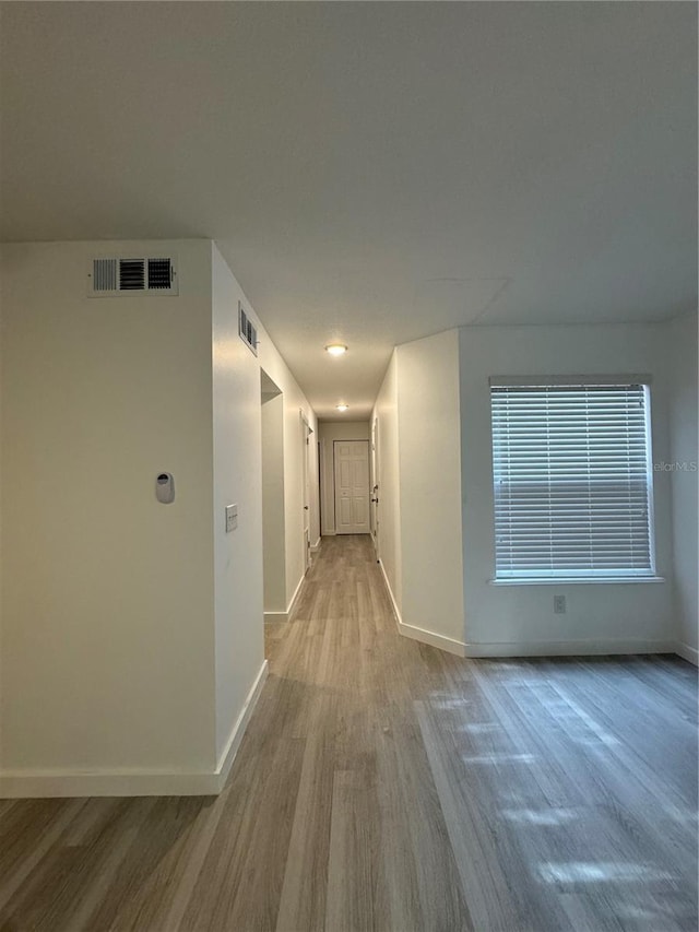 corridor with light hardwood / wood-style floors