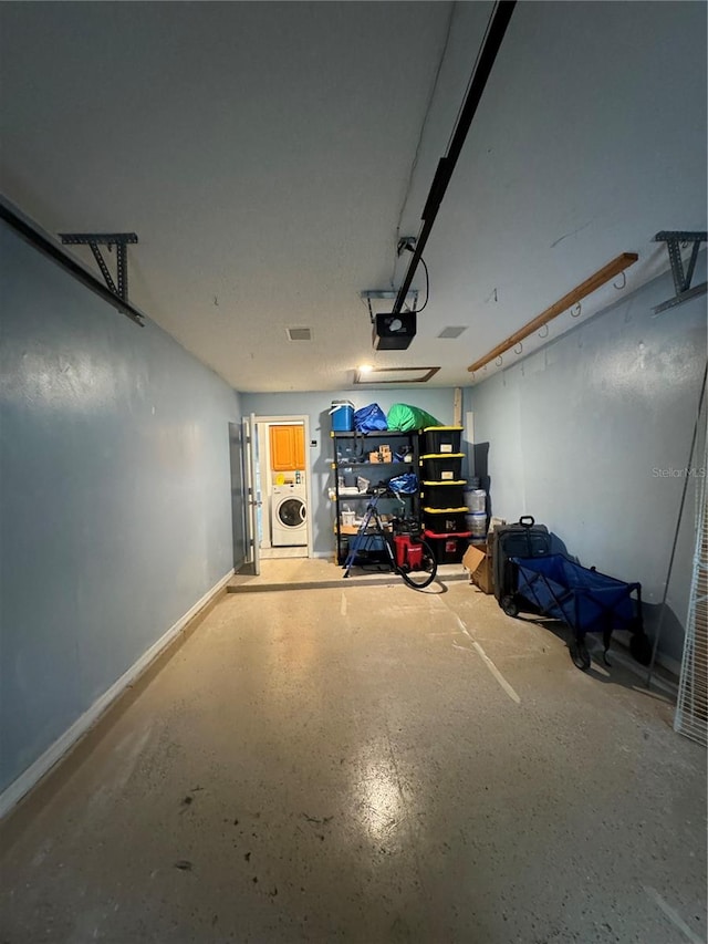 garage with a garage door opener and washer / dryer