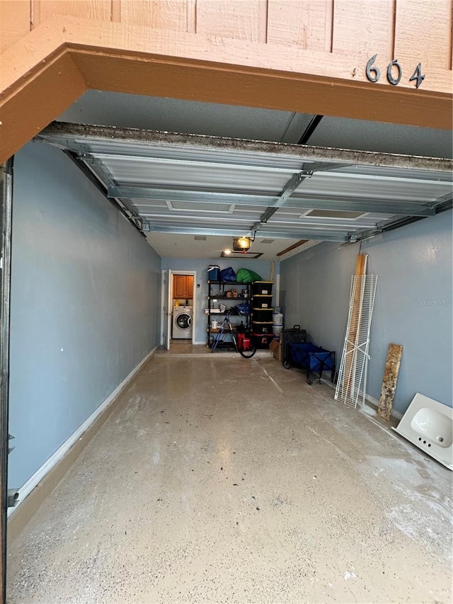 garage featuring a garage door opener and washer / dryer