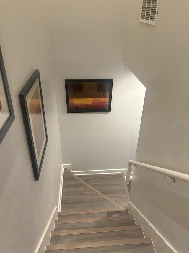 staircase with hardwood / wood-style floors