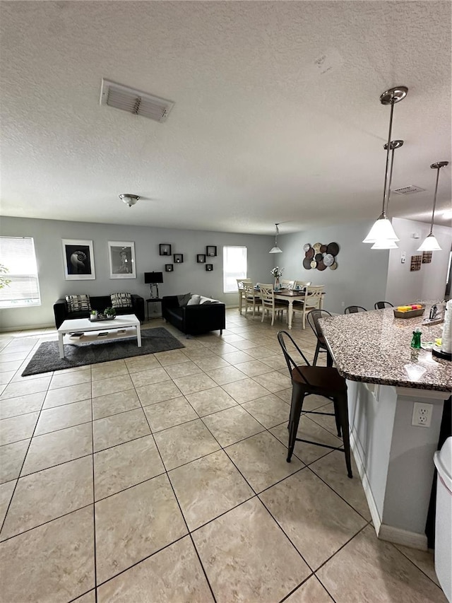 tiled living room featuring a textured ceiling