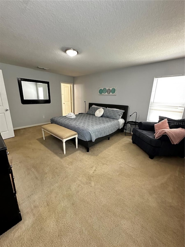 bedroom with a textured ceiling and carpet flooring