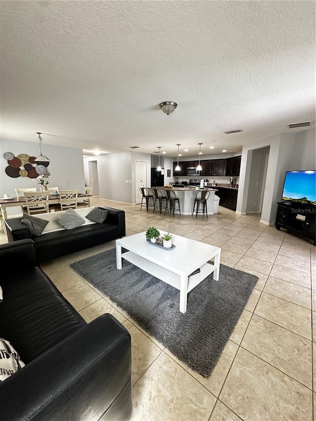 living room with a textured ceiling and light tile patterned flooring