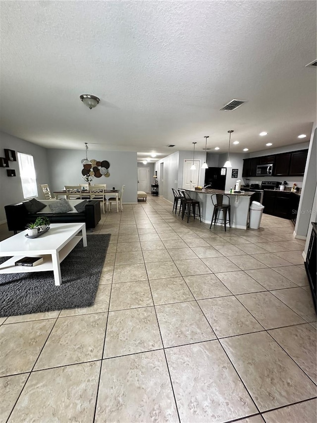 living room with a textured ceiling and light tile patterned floors