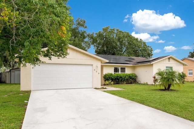 ranch-style house with a garage, a front lawn, and solar panels