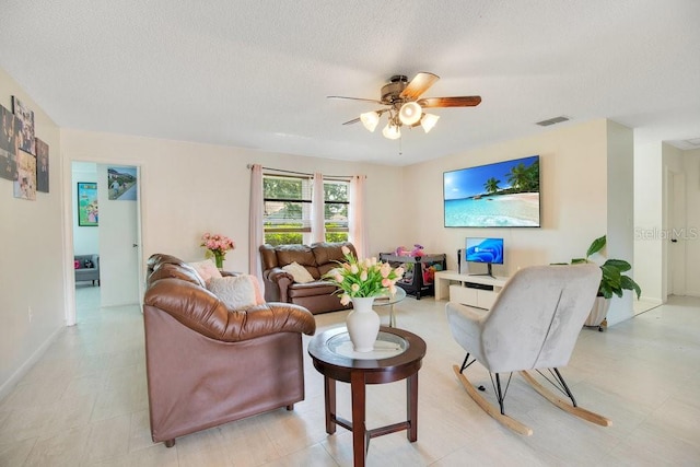 living room featuring ceiling fan and a textured ceiling